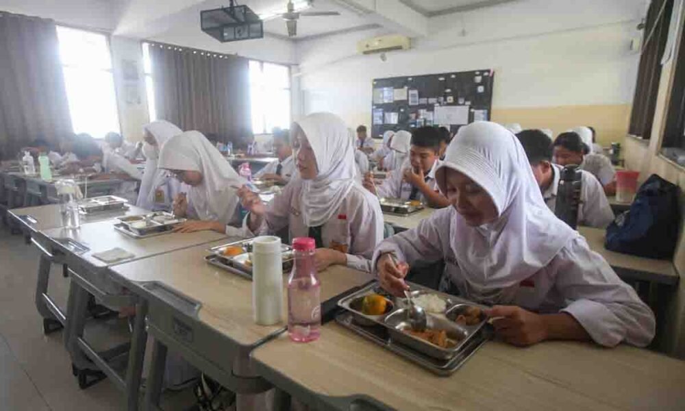 Seorang murid menyantap makanan bergizi gratis di SD Barunawati, Palmerah, Jakarta Barat