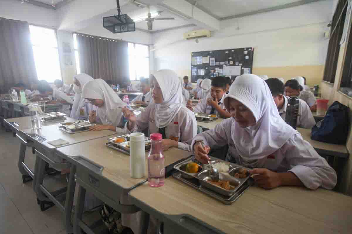 Seorang murid menyantap makanan bergizi gratis di SD Barunawati, Palmerah, Jakarta Barat