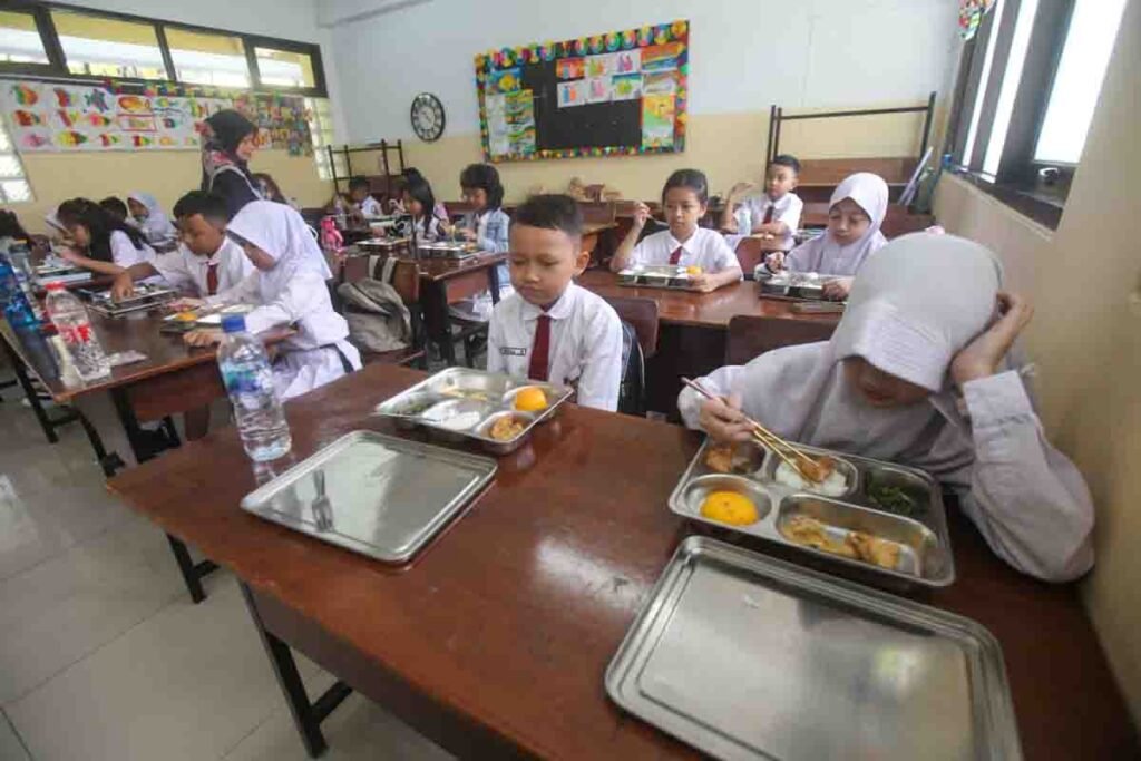 Seorang murid menyantap makanan bergizi gratis di SD Barunawati, Palmerah, Jakarta Barat