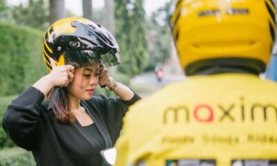 Penumpang mengenakan helm sebelum menggunakan layanan transportasi daring Maxim Indonesia