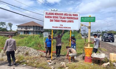 Personel Polsek Kuala Kencana memasang papan larangan memasuki kawasan Kali Wania di Jalan Tenas DWJ, Mimika