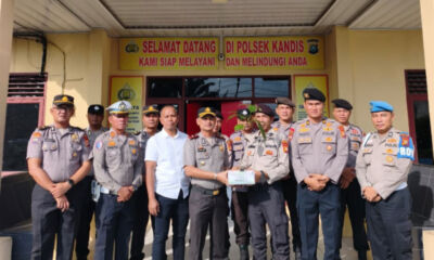 Kapolsek Kandis menyerahkan bibit pohon matoa kepada personel yang berulang tahun di halaman Mapolsek Kandis.