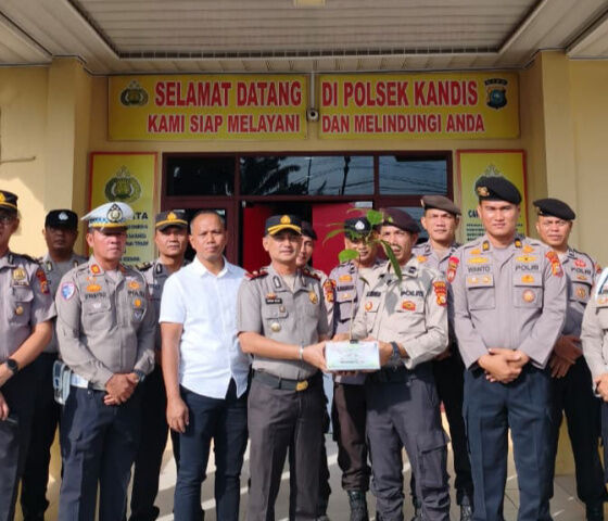 Kapolsek Kandis menyerahkan bibit pohon matoa kepada personel yang berulang tahun di halaman Mapolsek Kandis.