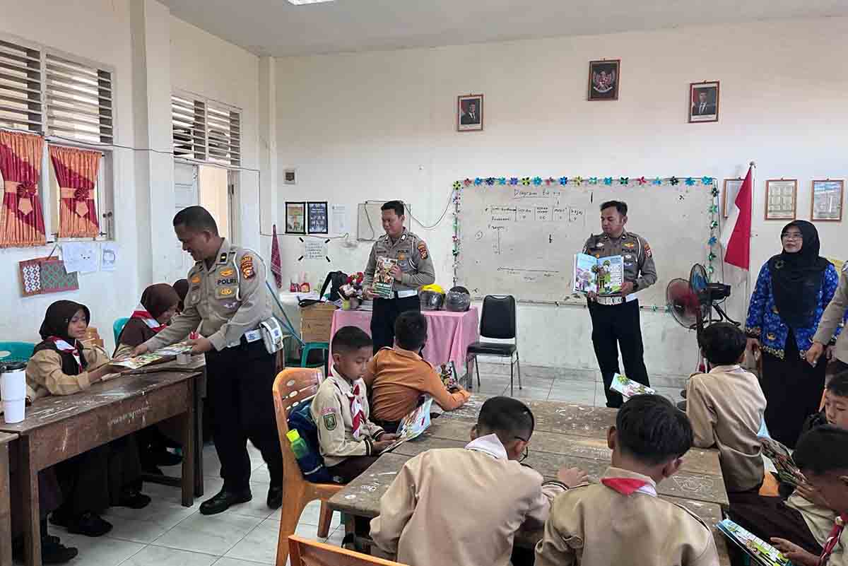 Personel Satlantas Polres Indragiri Hulu membagikan Buku CETAR kepada siswa SD Negeri 018 Sekip Hulu saat program Green Policing di Rengat, Selasa (02/6/2026).