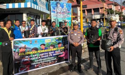 Personel Satlantas Polres Inhu membagikan bibit pohon kepada pengendara di Simpang Pos Persahabatan Rengat.