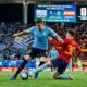 Foto aksi pertandingan Piala Dunia 2026 antara Uruguay dan Spanyol di Stadion Guadalajara, Meksiko. Gelandang Uruguay Federico Valverde (nomor 15) sedang mendribel bola sambil dibayang-bayangi oleh pemain Spanyol Gavi (nomor 30) yang mencoba melakukan tekel sliding. Di latar belakang, papan skor menunjukkan skor 1-1 pada menit ke-78.