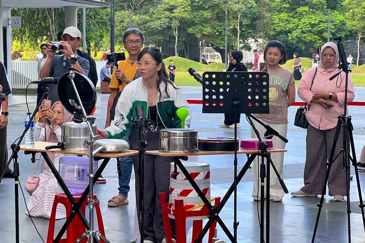 Marissa Sutanto memperagakan permainan drum panci menggunakan centong kayu dalam acara komunitas musik.
